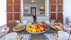 Una tavola imbandita con prodotti per la colazione, tra cui frutta, pasticcini e bevande.