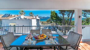 Un balcone con tavolo apparecchiato per la colazione, con vista sulla costa.