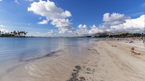 A beach with clear skies and calm water, sandy shore, and distant hills. - 1st line apartment in Alcudia Beach CAR (Alcúdia)