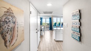A hallway leading to a kitchen with a view of the outdoors. - Sea Gull #103: Beachfront 2 Bedroom 2 Bathroom With Spectacular Views and 24 Hour Management (Port Aransas)