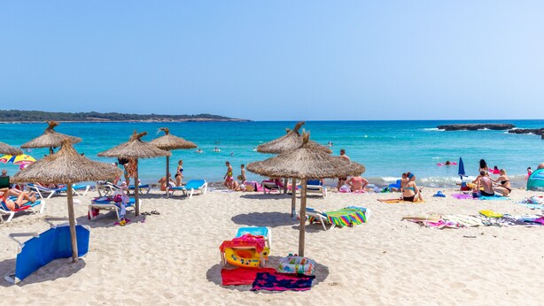 A beach with sun loungers, umbrellas, and a clear blue sky. - Urban style vacation home in S'Illot 5 minutes from Sa Coma and Cala Morlanda (S´illot-Cala morlanda)