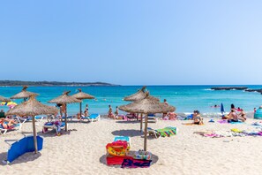 A beach with sun loungers, umbrellas, and a clear blue sky. - Urban style vacation home in S'Illot 5 minutes from Sa Coma and Cala Morlanda (S´illot-Cala morlanda)