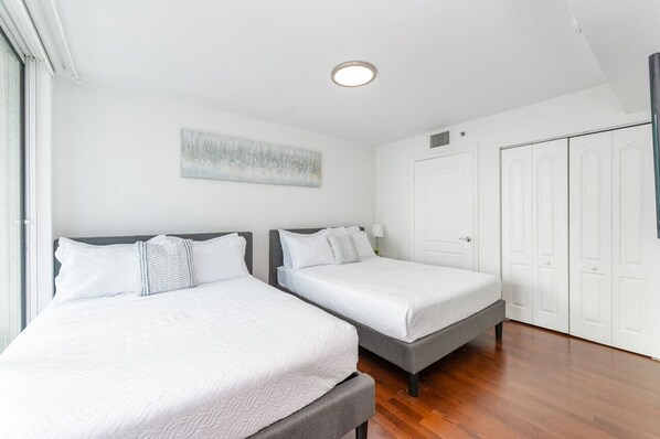 A bedroom with two beds, a ceiling light, a painting, and a wardrobe. - 3815 - Stunning Clean 3BR APT @Brickell, Free Parking (Miami)