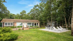 A house with a backyard patio, a small deck, and a lawn. - Rex- East Hampton Cottage- 5 stars (East Hampton)