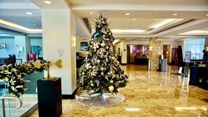 Un sapin de Noël dans un hall d’entrée doté d’un sol en marbre et d’une décoration moderne.