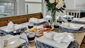 A dining table set with plates, glasses, cutlery, and a centerpiece of white flowers. - Stunning Luxury Lake Waterfront Home w/Fire pit! (Horseshoe Bay)