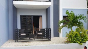 A modern building with a balcony, a small garden area, and a palm tree. - LUXURY APARTMENT WITH JACUZZI, 5MINUTES FROM THE BEACH (Residencial Romana)