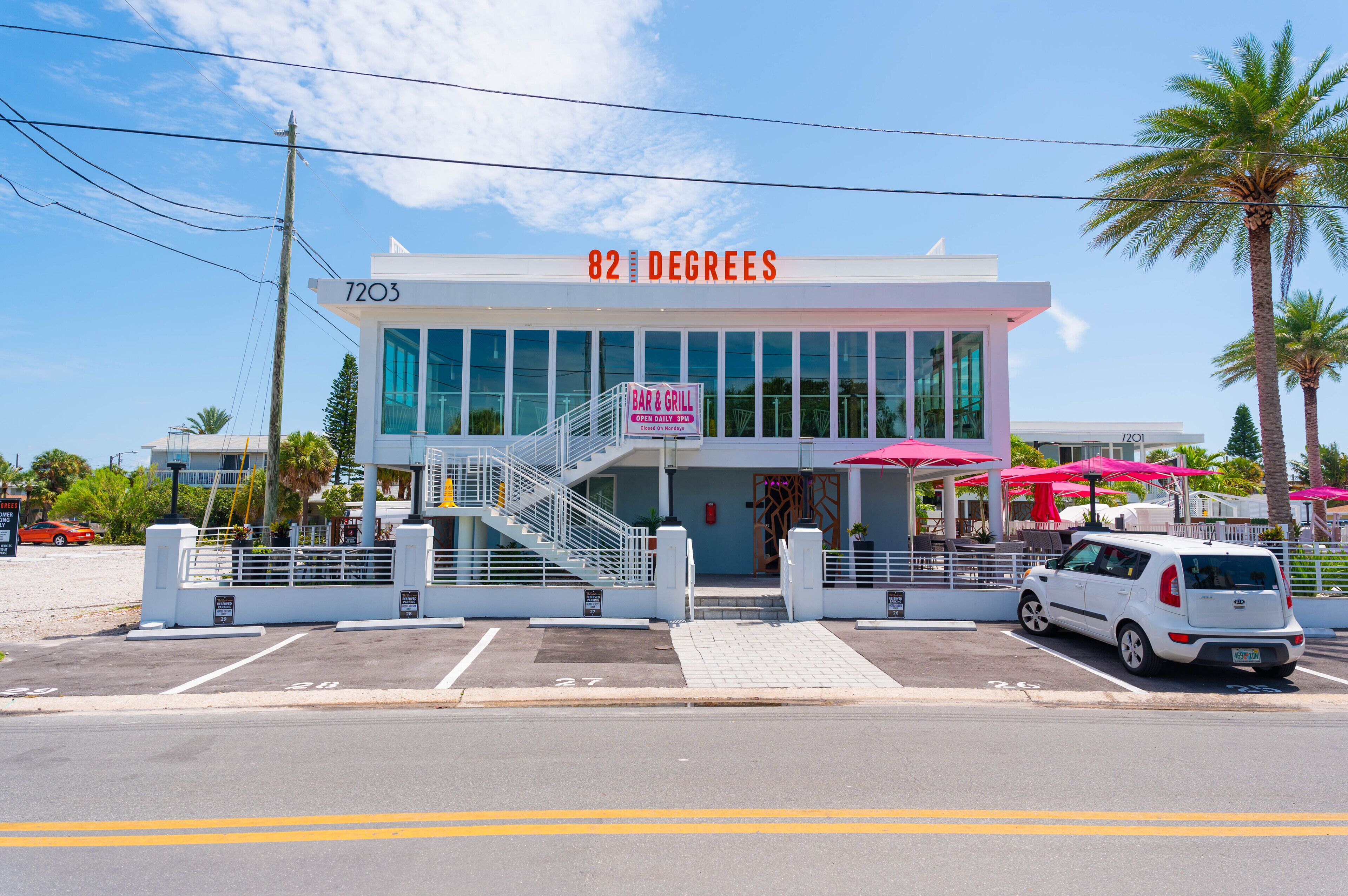 Un edificio moderno con un letrero que dice "82 DEGREES" y un letrero que indica "BAR & GRILL".