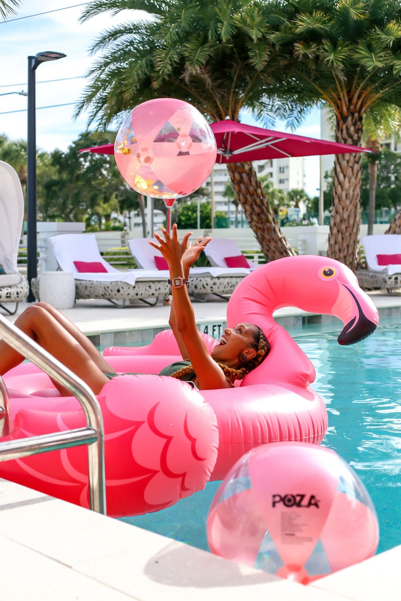 A pool area with lounge chairs and a flamingo float.
