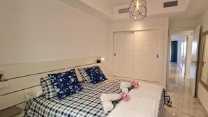 A modern bedroom with a large bed, checkered bedding, and a mirror on the wall.