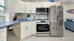 A modern kitchen with white cabinets, a stainless steel refrigerator, an oven, and a microwave. - Newly Remodeled-150 Yards to Beach and Restaurants! (Sarasota)