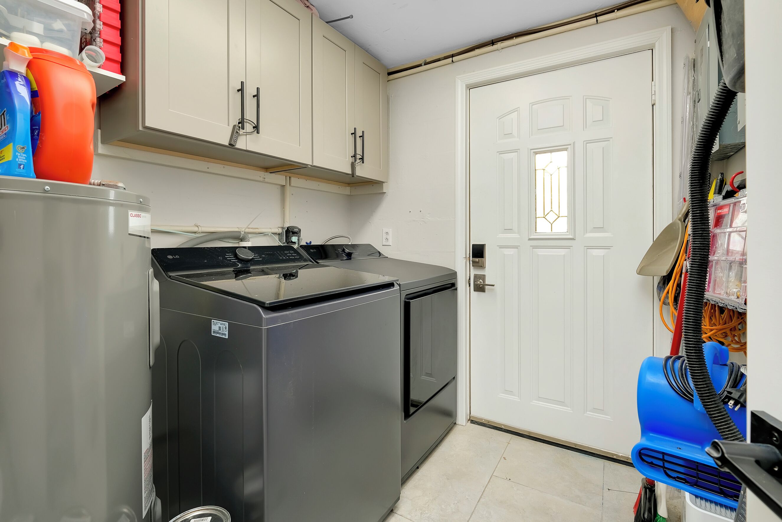 Cocina compacta con lavadora, secadora y una puerta con ventana.