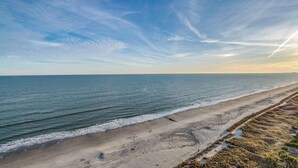 A beach with a clear sky and visible contrails. - North Myrtle Beach Oceanfront Condo w Lazy River (North Myrtle Beach)