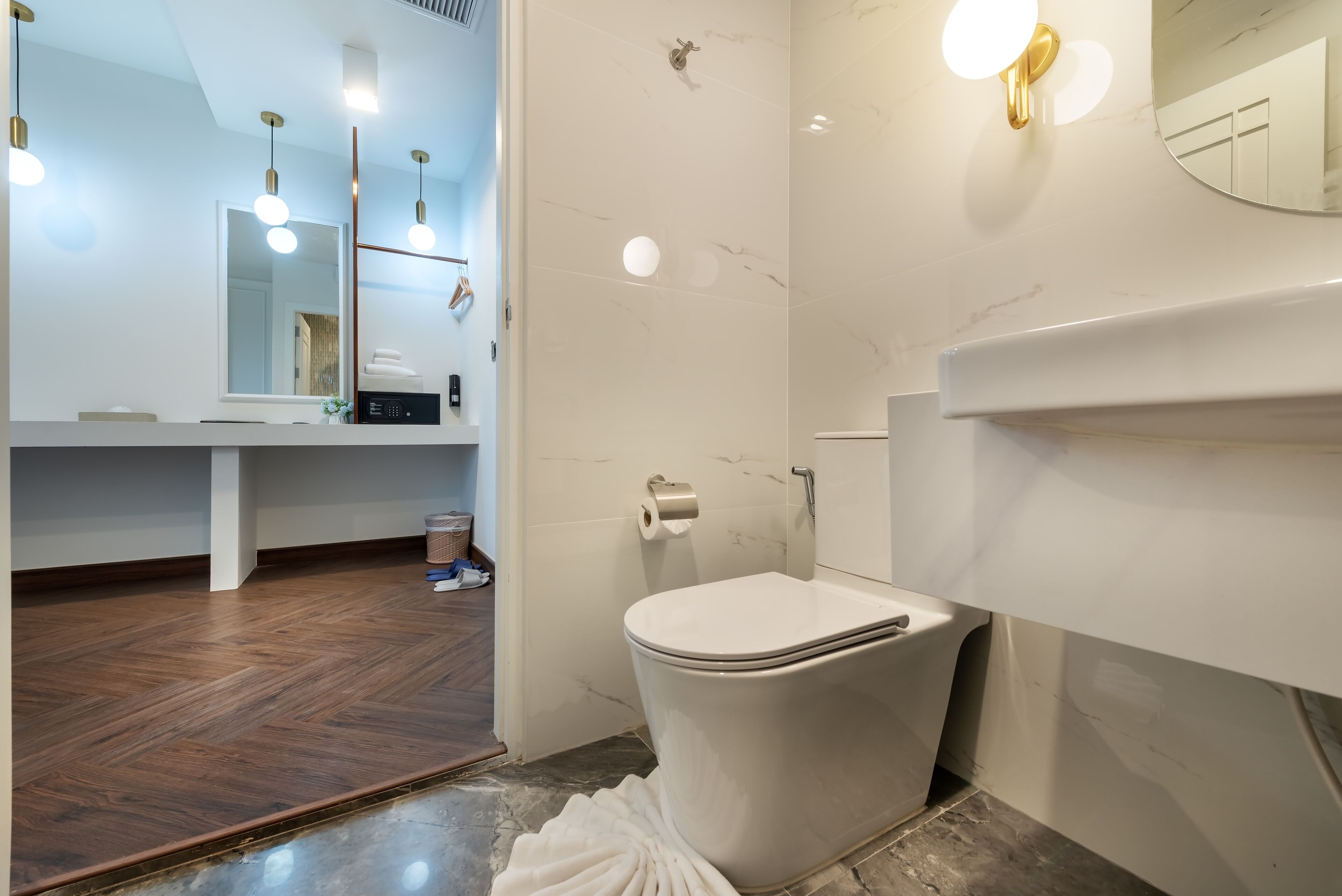 Une salle de bain moderne équipée de toilettes, d’un lavabo et d’un miroir.