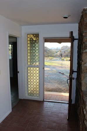 A doorway with a decorative glass panel and a stone wall.