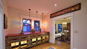 A modern kitchen with a wooden island, pendant lights, and a view into the dining area.