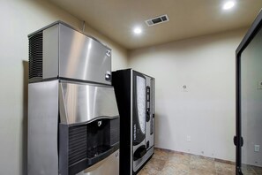 A kitchenette with a stainless steel refrigerator, a black oven, and a microwave.