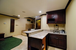 Una cocina con armarios de madera oscura, encimera de granito y lavamanos integrado.