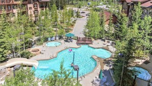 Un complexe hôtelier doté de plusieurs piscines, d’un toboggan aquatique et offrant une vue sur un paysage montagneux.