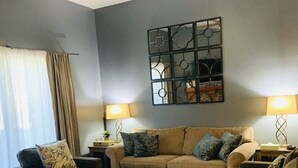 Un salon équipé d’un ventilateur de plafond, d’un ensemble de canapés, d’une table basse et de deux lampes.