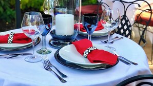 Una mesa dispuesta para una comida, con un candelabro en el centro, copas de vino y cubiertos.