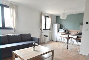 Relax in a cozy living area with a sofa and coffee table, and enjoy a city view from large windows.