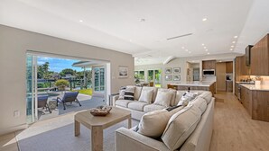 A spacious living area with a sofa, coffee table, and a view of a marina.