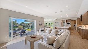 A spacious living area with a sofa, coffee table, and a view of a marina.
