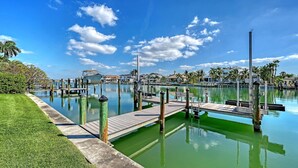 A marina with docks, calm water, and a clear sky.