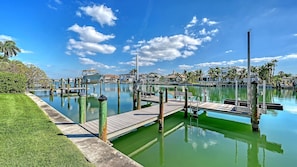 A marina with docks, calm water, and a clear sky.