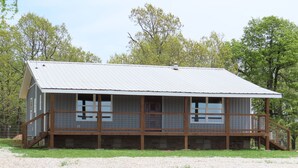 A two-story building with a metal roof and wooden deck, surrounded by trees. - 3/4 Mile from Wilderness Rider Buffalo Ranch,near Buffalo River w/RV Elec Hookup (Kingston)