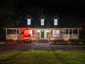 Een huis met veranda, een voordeur en een grote opblaasbare kerstman.