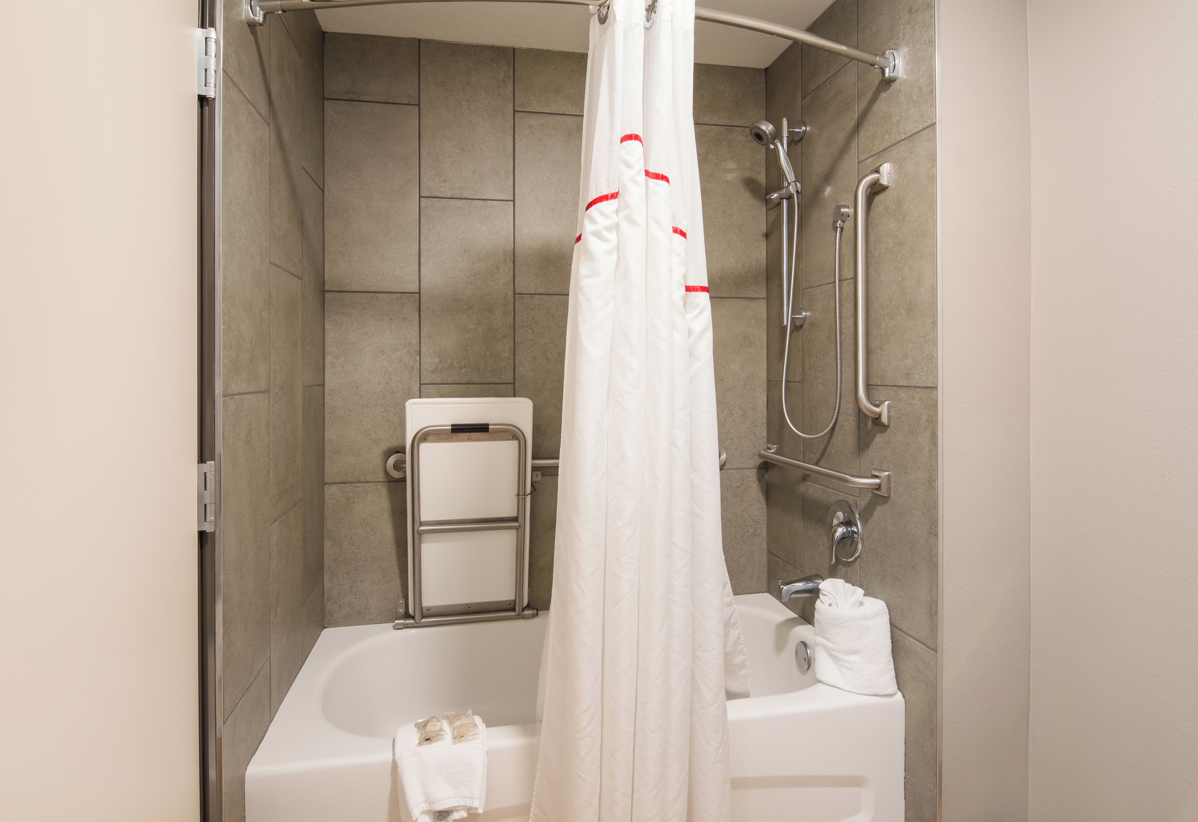 Et badeværelse med bruser, badekar og toilet.