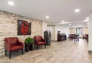 A Red Roof Inn lobby with seating, a self-service kiosk, and a projection screen in the background. - Red Roof Inn Chester (Chester)