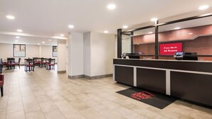 A hotel reception area with a counter, a digital screen, and a sign indicating free Wi-Fi. - Red Roof Inn Chester (Chester)