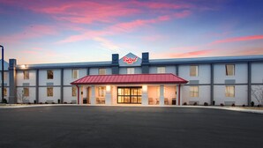Un hôtel avec un toit rouge et une enseigne indiquant « Red Roof Inn ».