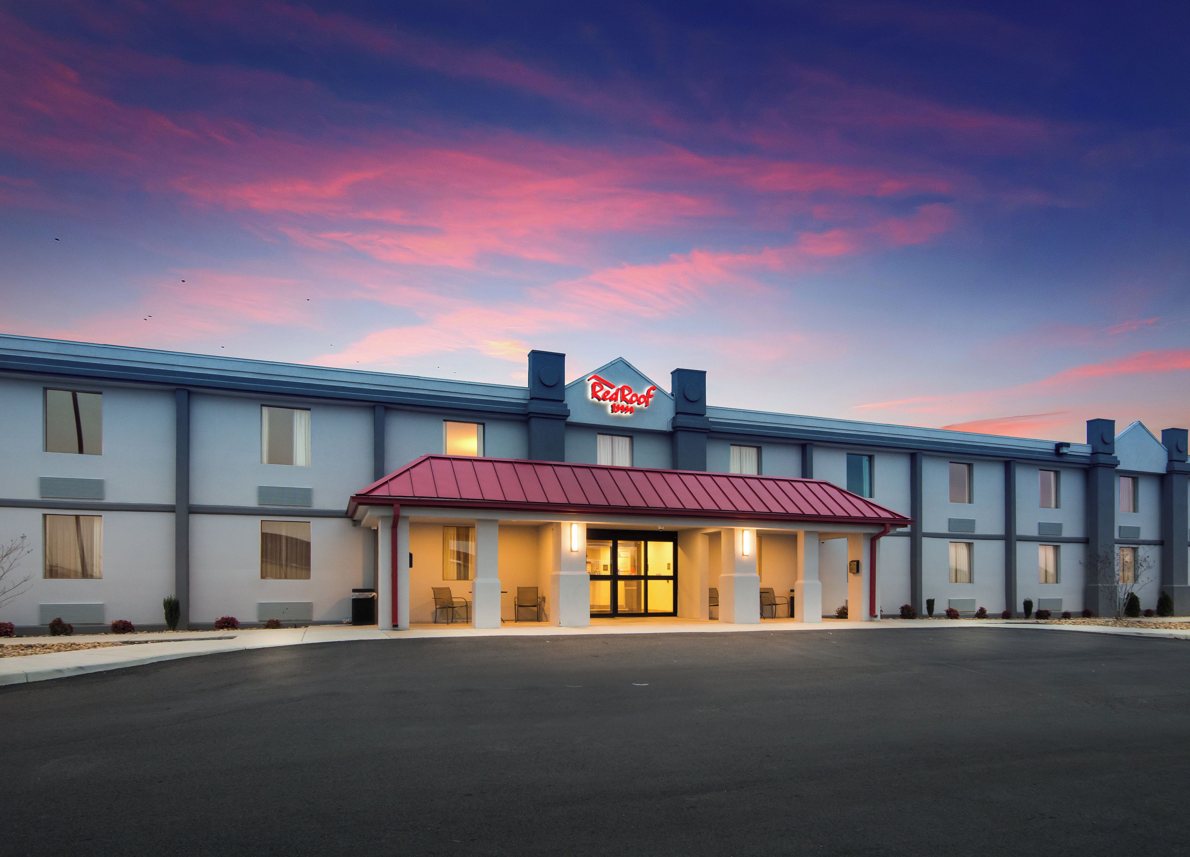 Et Red Roof Inn hotel med rødt tag og en række værelser.