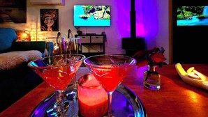 Ein gemütliches Wohnzimmer mit Fernseher, Kamin und Bar, komplett mit Gläsern.