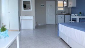 Un dormitorio con cama, escritorio y armario.
