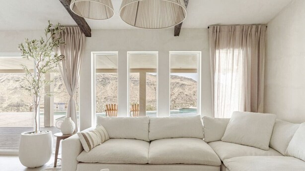 A modern living room with a large sectional sofa, a coffee table, and a potted plant. - Wind Hill in Pioneertown & Joshua Tree (Yucca Valley)