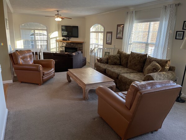 A living room with a fireplace, leather chairs, a sofa, and a television. - Buck's Run Breathtaking long distance valley views (Cooperstown)