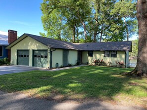Set amidst lush trees, this charming home offers a serene environment and a well-maintained yard with a garden and lawn.