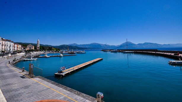 A harbor with boats, a long pier, and a bridge in the background. - CASA VACANZE CALIPSO (Scario)