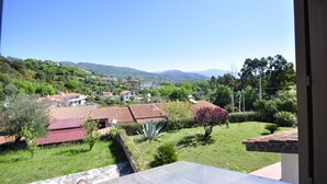 A residential area with houses, a garden, and a view of distant hills. - CASA VACANZE CALIPSO (Scario)