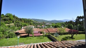 A hillside village with terracotta-roofed houses, lush greenery, and distant mountains. - CASA VACANZE CALIPSO (Scario)