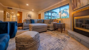 A spacious living room with a large window, a fireplace, and a cozy seating area.