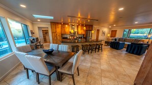 A spacious kitchen with wooden cabinets, a central island, and bar stools.