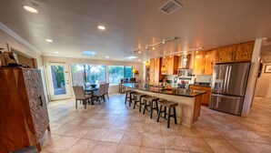 A spacious kitchen with a central island, wooden cabinets, and stainless steel appliances.