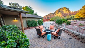 A patio with outdoor furniture, a fire pit, and a view of a mountain.