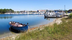 Un port de plaisance avec des bateaux amarrés, un petit bateau au premier plan et des bâtiments en arrière-plan.